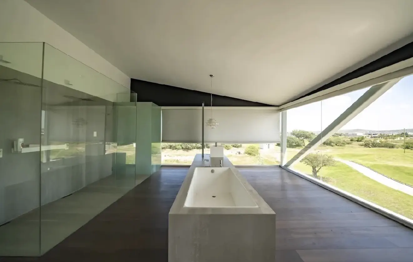 Bano principal con tina freestanding y vista al green